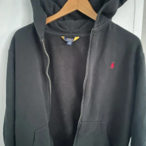 Svart sip hoodie från Polo Ralph Lauren - Säljer en svart hoodie från Polo Ralph Lauren med dragkedja och huva. Strl S