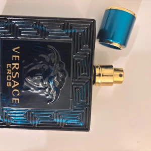 Versace Eros Parfym - Säljer en elegant Versace Eros parfym i en fyrkantig, blå flaska med guldiga detaljer. Flaskan har ett intrikat mönster och ett lock i matchande blått och guld. Perfekt för den som vill ha en doft med stil och karaktär. Verace eros EDT har en väldigt stark doft och håller i 7-10 timmar. Den har doften av Vanilj 🍦🍨, Grön Äpple 🍏, aromatik. Kan mötas i Kista, Stockholm