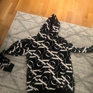 Calvin klein jeans hoodie - Säljer en gammal calvin klein hoodie som jag hade under högstadiet. Numera har den stått sedan man gick ut ur nian. Köpt från kidsbrandstore så hoodien är använd och gammal men i god skick förutom lite damm då den har bara stått