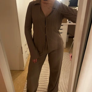 Beige set med skjorta och byxor - Snyggt beige set med långärmad skjorta och matchande byxor från gina tricot.