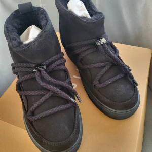 Svarta boots från Inuikii - Snygga svarta boots från Inuikii i mocka med snörning. Perfekta för kyligare dagar med sin höga design och robusta sula. Skorna har en stilren look med Inuikii-logga på baksidan.