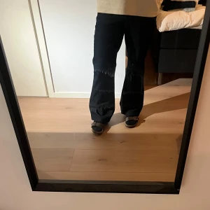 Mörkblå bootcut jeans - Snygga mörkblå bootcut jeans med klassisk design. De har en bekväm passform och är perfekta för en stilren look. Jeansen har fickor både fram och bak samt en knapp- och dragkedjestängning. Passar någon med storlek 31-33 i jeans