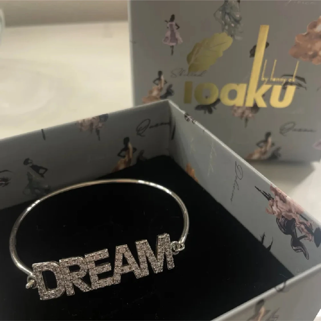 Silverfärgat armband med texten DREAM från Ioaku
