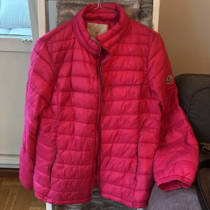 Rosa lättvikts dunjacka  - Säljer en snygg rosa lättvikts dunjacka. Jackan har en quiltad design och dragkedja framtill. Perfekt för kyligare dagar och ger en färgklick till din outfit.