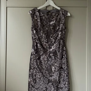 Glittrig klänning från Ralph Lauren - Säljer en elegant glittrig klänning från Ralph Lauren i en vacker silverfärg. Klänningen har en öppen rygg och är täckt med paljetter som ger en lyxig känsla. Perfekt för speciella tillfällen! ✨Aldrig använd och prislappen kvar. US-storlek 4, d v s 32-34 i svensk storlek. Nypris 2400kr.