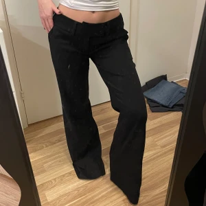 Svarta byxor från ichi - Snygga svarta raka byxor från ichi i storlek S. Byxorna har en klassisk design med raka ben och praktiska fickor med knappar baktill. Lågmidjade och väldigt mycket flare nertill. Passar en som är runt 170-175cm lång. Jag är 160 för referens 