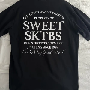 Svart t-shirt från Sweet SKTBS - Snygg svart t-shirt från Sweet SKTBS med tryck både fram och bak. Perfekt för en avslappnad stil. Tillverkad i mjukt material för extra komfort.