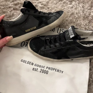 Svarta sneakers från Golden Goose - Intressekol!! Säljer vid bra bud! svarta Golden Goose sneakers med stjärndetalj på sidan och GGDB/SSTAR-tryck i guld. Allt kommer med låda, dustbag osv skriv om du har frågor❤️