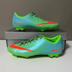 Nike mercurial vapor 9 - Snygga Nike Mercurial fotbollsskor i en fräsch grön färg med orange detaljer. Skorna har en smidig design med snörning och är perfekta för fotbollsplanen. Den stora Nike-loggan på sidan ger en extra touch av stil. (Priset kan diskuteras!)