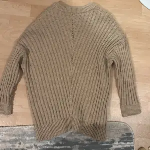 Säljer en mysig beige stickad tröja med ribbad design. Perfekt för kyliga dagar med sin långa ärmar och bekväma passform. Passar både till vardags och lite finare tillfällen. 🧶✨