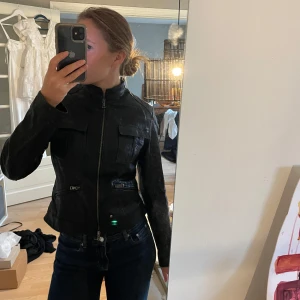 Svart skinnjacka från Vitulli - Äkta skinnjacka köpt i Florens. En snygg svart skinnjacka från Vitulli. Jackan har en cool dragkedja framtill och praktiska fickor med dragkedjor. Den är i bra skick och perfekt för höst och vår. Passformen är normal och den har långa ärmar. Perfekt för en stilren look! Italiensk storlek 44 passar en 34/36, 