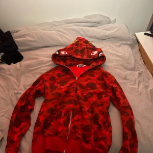 Röd bape ziphoodie - Säljer denna bape hoodien, då jag inte använder den längre, storlek xl men är väldigt liten i sin storlek, passar m/x, 
