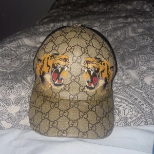 Gucci keps tiger - Säljer nu min Gucci keps haft den ett tag den är i bra skick men på framsidan är den lite missfärgad.                                                             Endast seriösa köpare och pris kan diskuteras