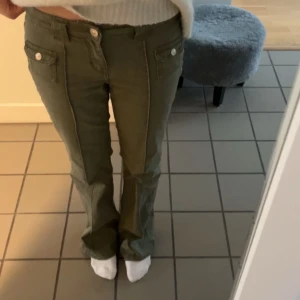 Gröna byxor med knappar - Säljer dessa sjukt snygga low waist gröna bootcut jeansen ifrån HM helt slutsålda! Super snygga nu till hösten!💕Väldigt sparsamt använda och inga defekter förekommer🩷Storlek 36 men passar också mig som har 38 i vissa jeans!