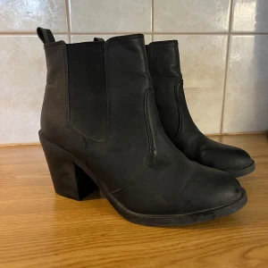Svarta boots med klack - Svarta klackskor / boots i storlek 37. Knappt använda, en tråd som sticker ut men inget trasigt