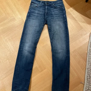 Blå jeans Jack & Jones - Säljer ett par snygga blå jeans från Jack & Jones i modellen Comfort Mike. De har en klassisk femficksdesign och en bekväm passform. Perfekta för både vardag och fest!