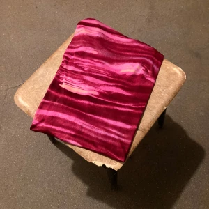 00-tal klänning - Tunn silkig klänning i melerat rödrosa mönster, går att ha med glipan i ryggen eller som urringning. Är också fin med byxor under.