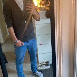 Grå cardigan från Polo Ralph Lauren - Säljer en snygg grå cardigan från Polo Ralph Lauren i storlek M. Den har en klassisk design med knappar inga fläckar skick 9/10 skulle nog strykas lite annars tvär fet. Perfekt för både vardag och lite finare tillfällen. Passar bra till jeans eller chinos.🏇