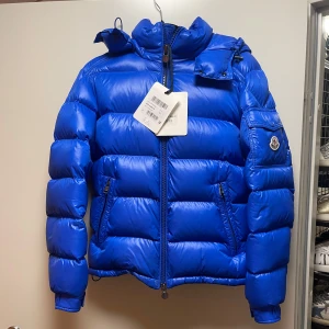 Moncler Maya Jacka - Säljer denna snygga blåa Mayan använd en vinter, köpt för 12,999kr på NK i Sthlm. Säljes för 9500kr kvitto & tags finns kvar. (Storlek 2) S-M.