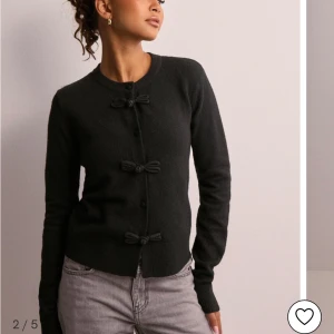 Stickad tröja med rosetter 🎀🎀 - Stickad cardigan från Nelly. Köpt för 400kr och har använt den ca 4 ggr. Jag tycker den är lite för liten för mig därför jag vill sälja den vidare! 🩷