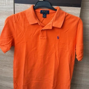 RL piké - Säljer en orange Ralph lauren piké i bra skick. Kom gärna med bud.