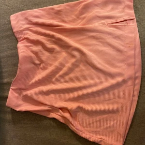 Rosa ribbad kjol från Divided Medium - Säljer en superfin rosa ribbad kjol från Divided. Den är i ett mjukt och stretchigt material .Kjolen har en enkel design med en liten slits på sidan för extra stil. Perfekt för både vardag och fest! 🌸Finns att hämta i västra Lund eller skickas mot porto.