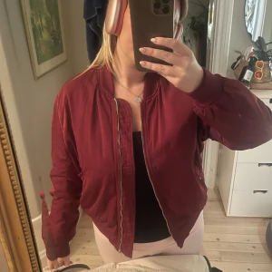 Vinröd bomberjacka  - Super fin jacka inför hösten! Den är storlek L men sitter mer som en S/M