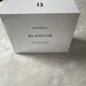 Byredo Blanche Eau de Parfum 100ml - Säljer en elegant Byredo Blanche Eau de Parfum. Förpackningen är stilren och vit med Byredos logotyp i svart. Perfekt för den som älskar en ren och fräsch doft.
