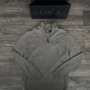 Grå halfzip från Polo Ralph Lauren - Säljer min polo Ralph lauren halfzip för tyvärr så har jag tröttnat på den. Den är autentisk köpt i polo Ralph lauren butiken i mall of Berlin i Tyskland. Betalde 2700kr för den och den är knappast använd och har inga tecken på användning så den e som ny. Jag har fortfarande kvar påsen men tyvärr inte kvittot. Skriv gärna till mig om ni har fler funderingar