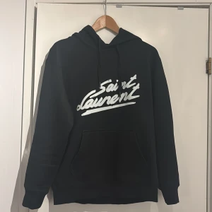 Saint Laurent Hoodie - En svart hoodie ifrån Saint Laurent, storlek S. Nypris är ca 7000kr och kvitto finns