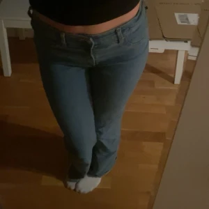 Blå jeans med bootcut - Snygga blå jeans med bootcut-stil och låg midja. Perfekta för en avslappnad look. De har en klassisk design med dragkedja och knapp framtill.