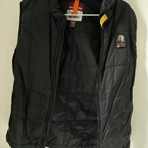 Parajumpers - Säljer en stilren svart quiltad väst från Parajumpers. Västen har en dragkedja framtill och en liten logotyp på bröstet. Perfekt för lager-på-lager under kyligare dagar.