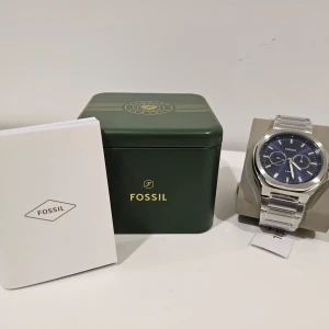 Fossil klocka - Silverfärgad, blå Fossil klocka. Klockan är helt oanvänd plastdkyden samt ettiketlapp sitter fortfarande kvar.