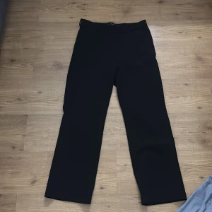 Svarta byxor från Vero Moda - Snygga svarta byxor från Vero Moda i storlek L. Byxorna har en klassisk design med rak passform och är perfekta för en stilren look. Tillverkade i ett bekvämt material som passar till många olika tillfällen.