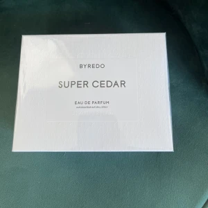 Super Cedar Eau de Parfum från Byredo 100ml - Upptäck den eleganta doften av Super Cedar från Byredo. Denna Eau de Parfum kommer i en stilren vit förpackning med subtil textur. Perfekt för den som älskar träiga och sofistikerade dofter. Tillverkad i Frankrike.