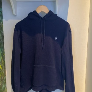 Mörkblå hoodie från Polo Ralph Lauren - Säljer en snygg mörkblå hoodie från Polo Ralph Lauren med ett tvär skönt material. Skicket är topp eftersom jag har använt den 1-2 gånger. Mitt pris :650 nypris: 2500. Tveka inte utan hör av er ang frågor osv!