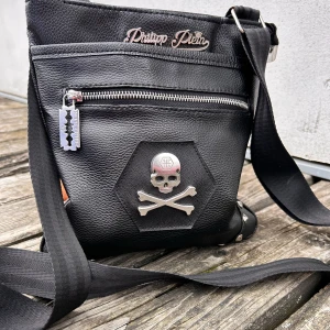 Liten Philipp Plein väska! - Liten Philipp Plein väska i hans klassiska design med rockiga detaljer. Justerbar axelrem och flera fack med dragkedja finns. Mått: 25 x 23 cm. Har några år på nacken men i mycket gott skick och inga skavanker. Metalldetaljerna är silvriga och endast något som reflekteras på några bilder.