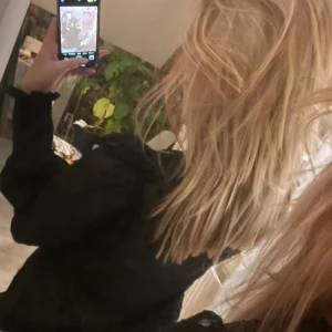 Svart blus med volangdetaljer - Snygg svart blus med volangdetaljer och prickigt mönster. Blusen har långa ärmar och en v-ringad design, perfekt för en stilren look. Pris kan alltid diskuteras❤️storleken är L men passar mer s/m om man inte vill ha den croppad