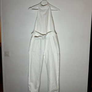 Jumpsuit  - Snygg vit jumpsuit från ASOS i denim med hög krage och öppen rygg. Den har en medföljande bälte i midjan och dragkedja baktill. Perfekt för en stilren look.🥰🥰🥰