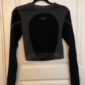 Svart/grå långärmad sporttopp  - Svart/gråranding sporttopp. Ej använd. Liten i storlek.