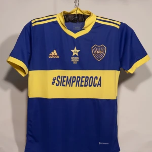 Boca Junior Special Edition - Boca Junior Special Edition. Det är en gul-blå fotbollströja med krage. Storlek M.                     Tröjan är helt ny och oanvänd!!                                                   Den hära tröjan är från när Boca Junior vann   Supercopa Argentina.                                                 Hör av er om ni har frågor!!!