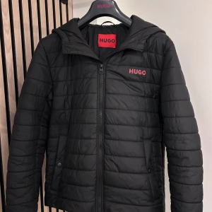 Svart jacka från Hugo boss  - Snygg svart quiltad jacka från Hugo. Använd några få gånger. Nypris 2500