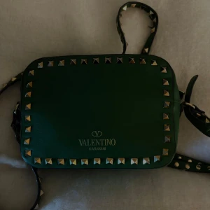 ❗️Byte❗️Valentino - ❗️BYTEN❗️Snygg grön axelväska från Valentino med coola nitar runt kanterna. Väskan har en justerbar axelrem och är perfekt för att ge din outfit en edgy touch. Den är tillverkad i skinn och har en praktisk dragkedja för säker förvaring. Nypris: 17 655 pga limited edition färgen