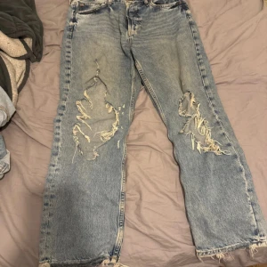 Blå jeans från JDY - Säljer ett par blå jeans från JDY i storlek L. De har en avslappnad passform med slitna detaljer på framsidan och klassisk femficksdesign. Perfekta för en casual look.