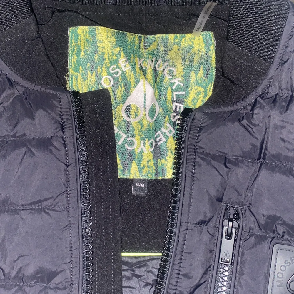 Köpt på Johnells i Linköping. Säljer en stilren svart dunväst från Moose Knuckles. Västen har en praktisk dragkedja framtill och en bröstficka med dragkedja. Perfekt för kyligare dagar och ger en modern look.. Takit.