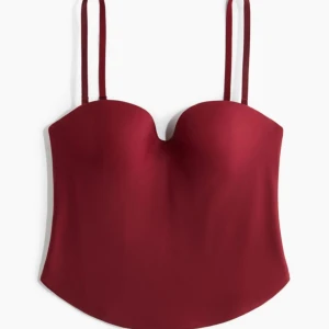 Vinröd korsettopp - Snygg vinröd korsettopp med smala axelband. Perfekt för en kväll ute eller en speciell tillställning. Toppen har en elegant och figurnära passform. Toppen är helt oanvänd med lappen kvar!💕