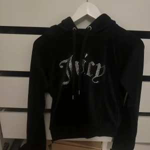 Svart hoodie från Juicy Couture - Säljer en svart hoodie från Juicy Couture med glittrande text på framsidan. Super fin utan defekter, knappast använd 