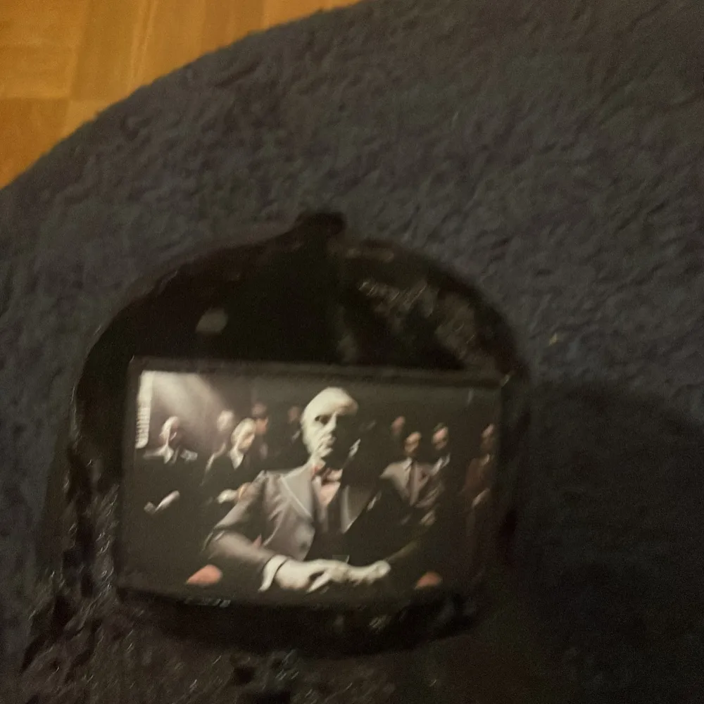 Snygg svart keps med ett tryck av en man i kostym på framsidan. Kepsen har ett nätmaterial på baksidan för bättre ventilation och en justerbar rem för perfekt passform.. Asusteet.