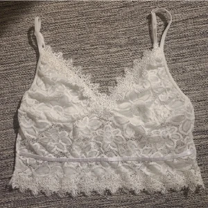 Vitt spetslinne - Vitt linne med blommig spets. Osäker på storlek men väldigt stretchig så passar mig som är S och även upp till L. Underdelen är genomskinlig och kuporna vita, så ingen bh behövs. Justerbara axelband. Aldrig använd. Skriv för fler bilder😁