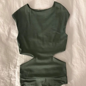 Grön snygg body - Snygg grön body med cut-out detaljer i midjan. Aldrig använd 